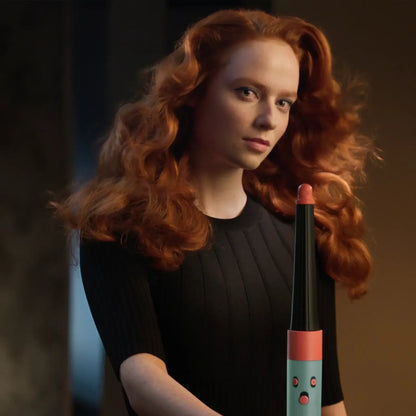 Model showcasing the Dyson Airwrap I.D. Patina & Topaz for styling straight to wavy hair in a modern setting.