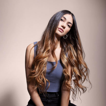 Sebastian Woman with long, wavy hair posing against a beige background
