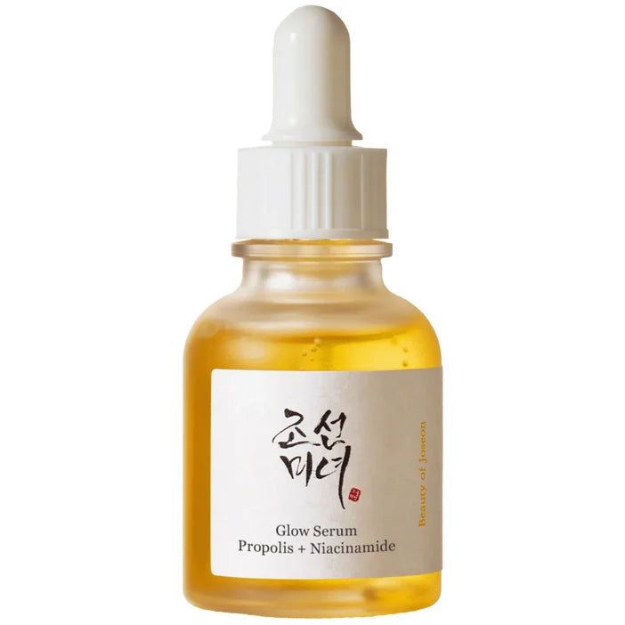 A clear glass dropper bottle filled with golden-yellow serum, featuring a white label with Korean text and 'Glow Serum Propolis + Niacinamide' printed below, set against a plain white background.