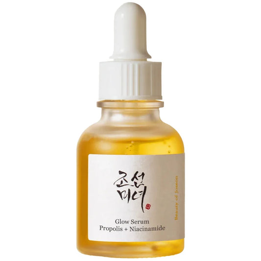 A clear glass dropper bottle filled with golden-yellow serum, featuring a white label with Korean text and 'Glow Serum Propolis + Niacinamide' printed below, set against a plain white background.