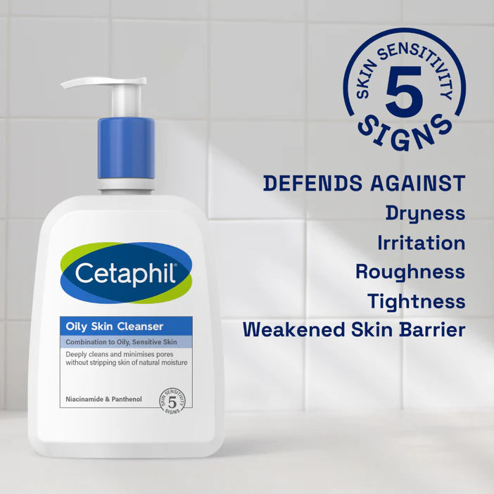Cetaphil oily skin cleanser bottle with text about skin care benefits on a tiled wall background