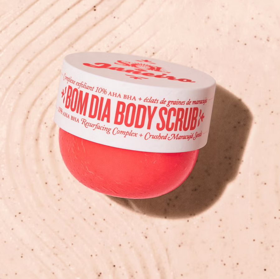 Sol de Janeiro Bom Dia Body Scrub 220g jar with exfoliating blend on textured surface.