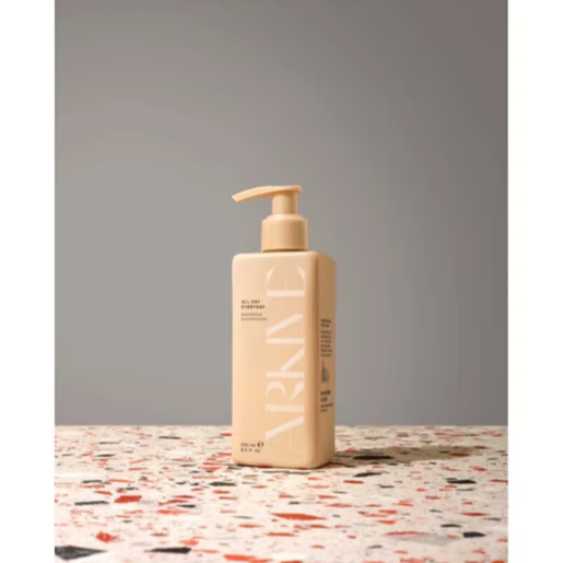 ARKIVE All Day Everyday Shampoo bottle on a textured surface, showcasing its minimalist design and pump dispenser.