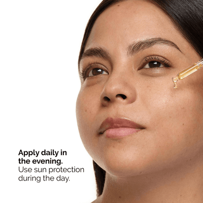 Woman applying The Ordinary Retinol 0.5% in Squalane serum on her face, promoting evening skincare routine.