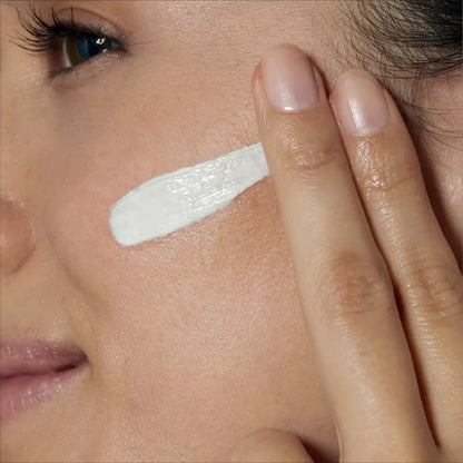 Woman applying CeraVe Facial Moisturising Lotion SPF25 white cream to her face with a finger