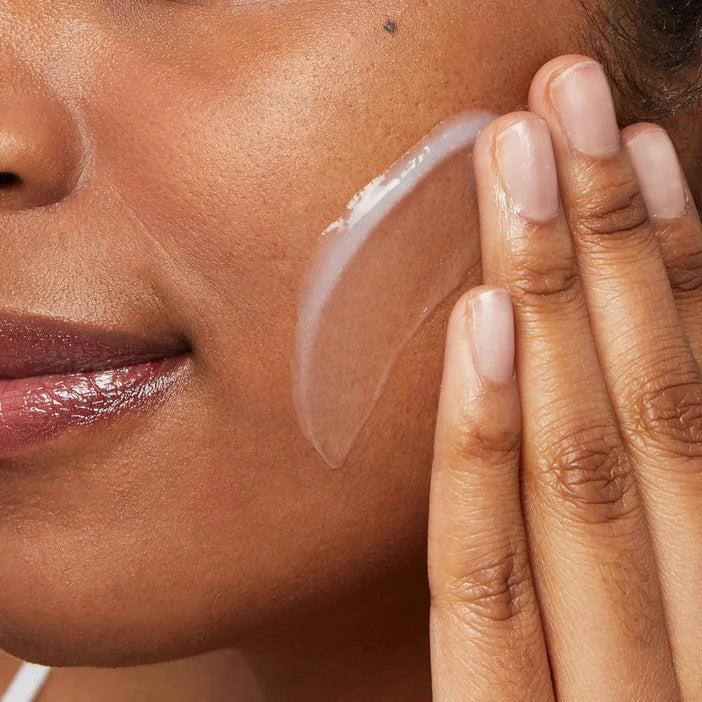 Close-up of a woman applying CeraVe Hydrating Cleanser to her face