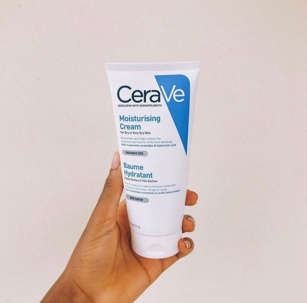 CeraVe moisturizing cream held in a hand against a plain background