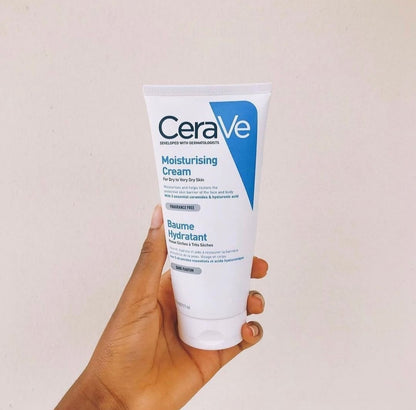 CeraVe moisturizing cream held in a hand against a plain background