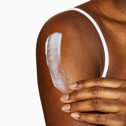 Person applying CeraVe Moisturising Cream 454g to their shoulder with a white background