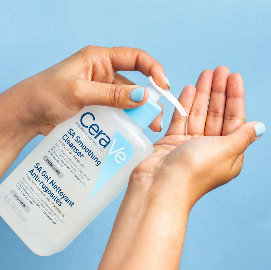CeraVe SA Smoothing Cleanser being applied to hands against a blue background