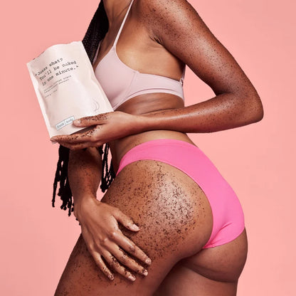 Person wearing pink underwear holding a product against a pink background