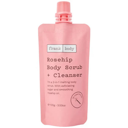 A pink squeeze pouch of frank body Rosehip Body Scrub + Cleanser, featuring a matching pink cap, on a solid white background.