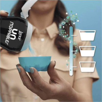 Person pouring Lenor Unstoppables Fresh scent booster into a blue bowl for laundry freshness.