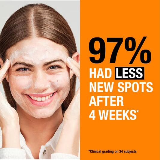 Woman applying Neutrogena skincare product with text about spot reduction after 4 weeks.