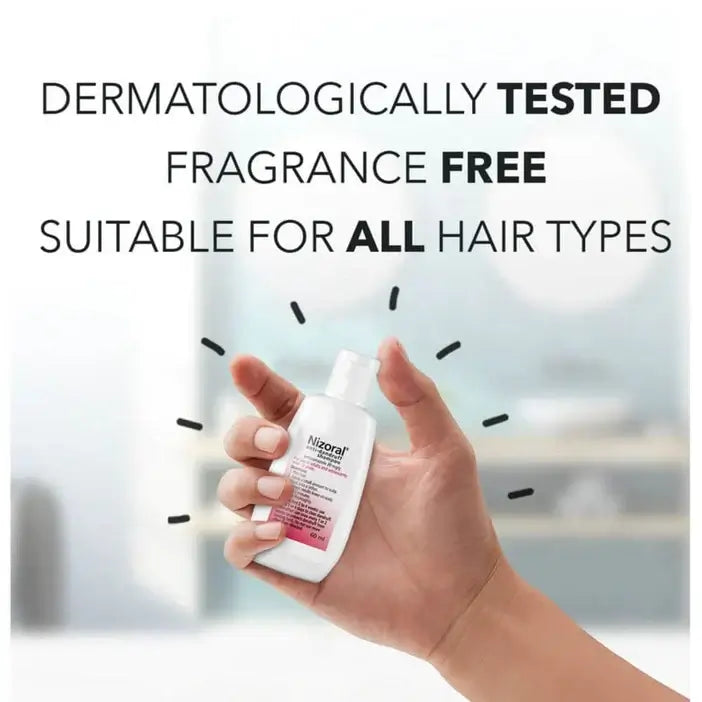Hand holding a bottle of Nizoral shampoo with text about dermatological testing and suitability for all hair types.