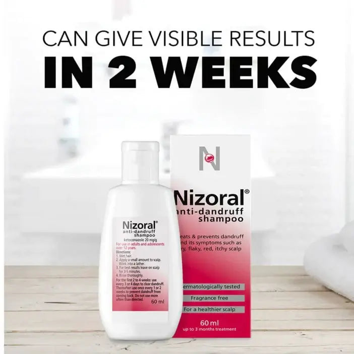 Nizoral anti-dandruff shampoo bottle and packaging on a wooden surface with text about visible results in 2 weeks.