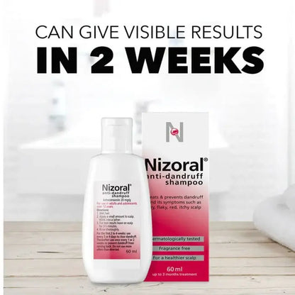 Nizoral anti-dandruff shampoo bottle and packaging on a wooden surface with text about visible results in 2 weeks.