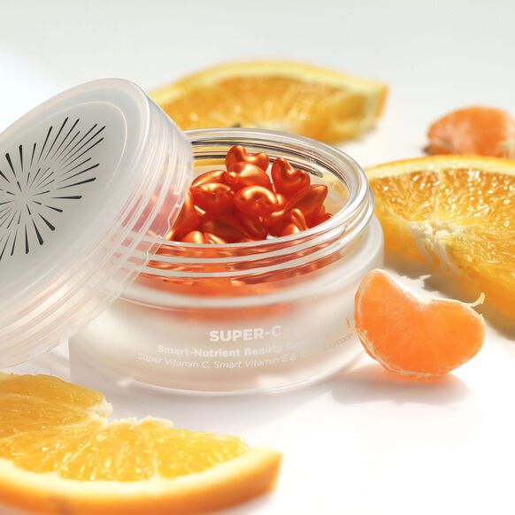 Jar of Oskia London Vitamin C 'Super-C' skincare product with sliced oranges on a white background