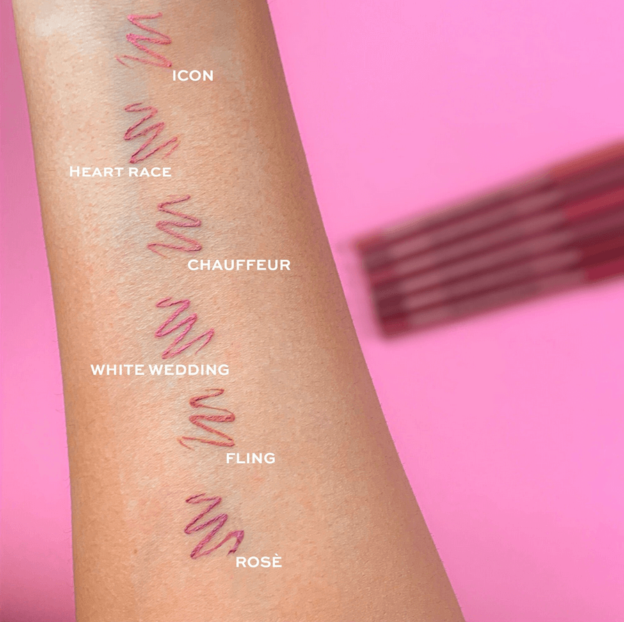 Arm with Revolution lipstick swatches labeled on a pink background