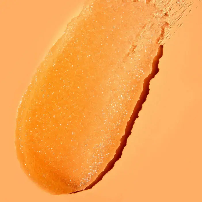 Close-up of TREE HUT Sugar Scrub Papaya Paradise 510g showing its orange, exfoliating texture on a soft background.
