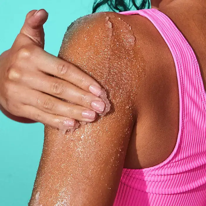 Person using TREE HUT Sugar Scrub Moroccan Rose on shoulder for smooth skin and gentle exfoliation.