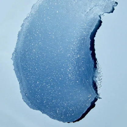 Close-up of a blue TREE HUT Sugar Scrub Exotic Bloom against a light blue background