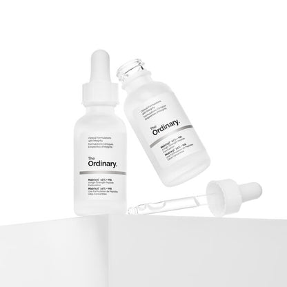 Two bottles of 'The Ordinary' serum with a dropper on a white background