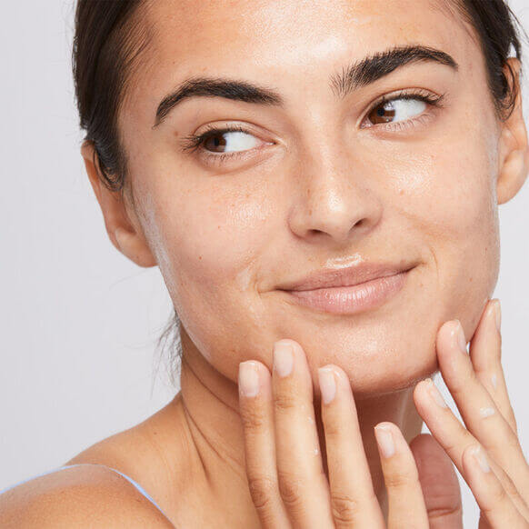 Woman applying Dermalogica Calm Water Gel for hydration on her face, showcasing radiant and healthy skin.