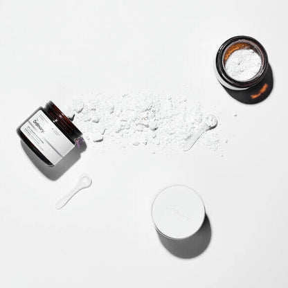 The Ordinary 100% L-Ascorbic Acid Powder, vitamin C in a jar, with powder spilled and measuring spoon.