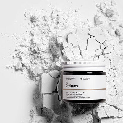 The Ordinary 100% L-Ascorbic Acid Powder jar against a textured white background of powder, showcasing its revitalizing skincare benefits.