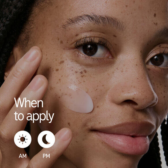Woman applying moisturizer with a label indicating AM and PM usage for skincare routine.