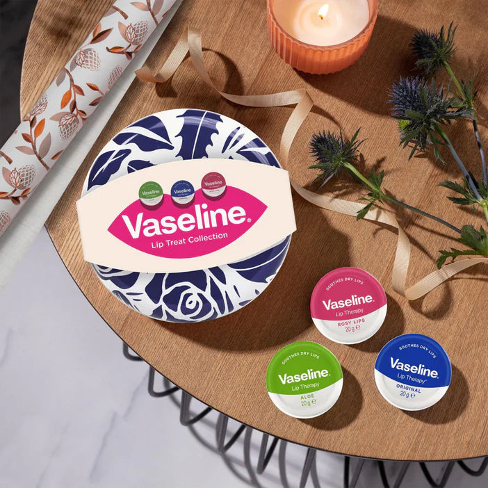 Vaseline lip balm collection on a wooden table with decorative elements.