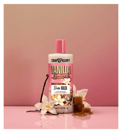 Soap & Glory Vanilla-licious Body Wash bottle surrounded by vanilla flowers and caramel, promoting a luxurious bath experience.