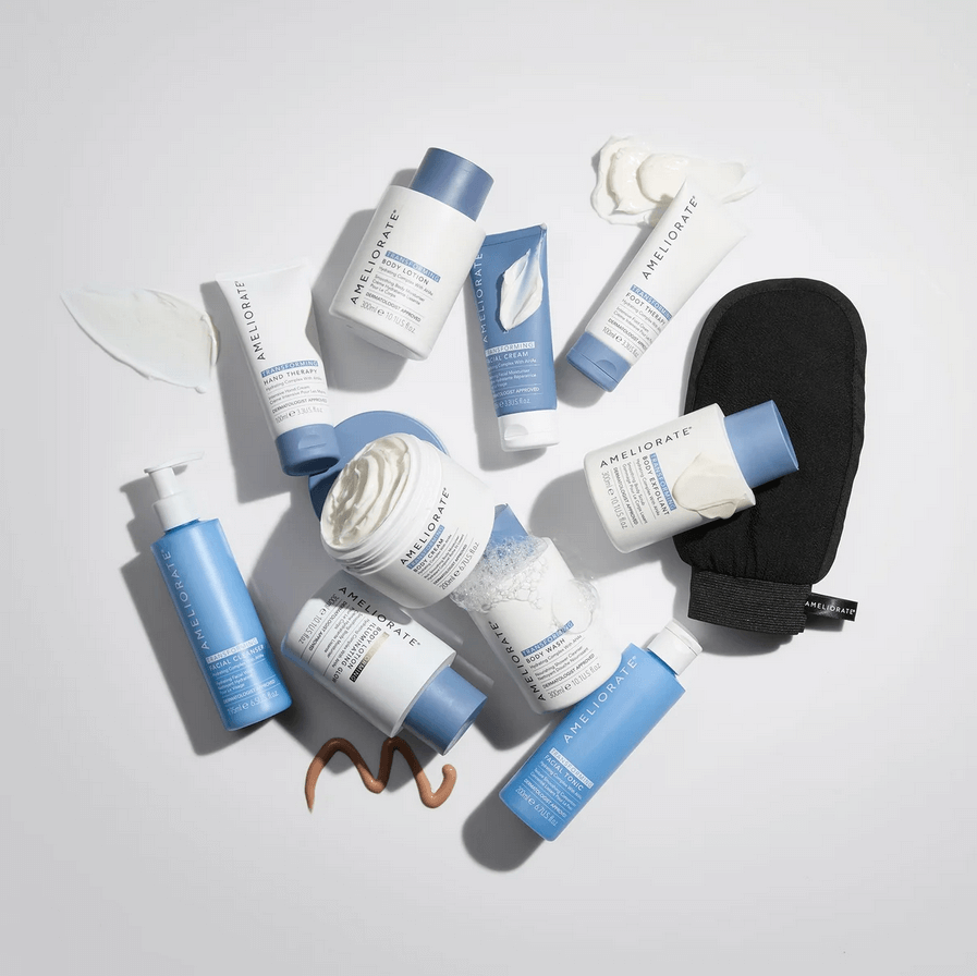 Collection of AMELIORATE skincare products with blue and white packaging on a light gray background