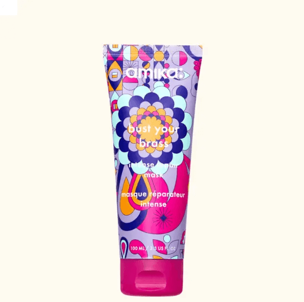 Amika Bust Your Brass Cool Blonde Intense Repair Hair Mask tube designed for illuminating blonde hair.