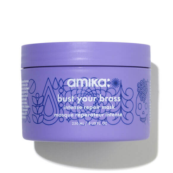 Amika Bust Your Brass Intense Repair Hair Mask in a purple jar, designed for vibrant cool blonde hair.