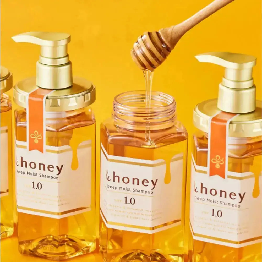 Bottles of 'honey' deep moist shampoo with a honey dipper on a yellow background