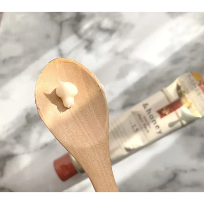 Wooden spoon with a dollop of cream against a blurred background