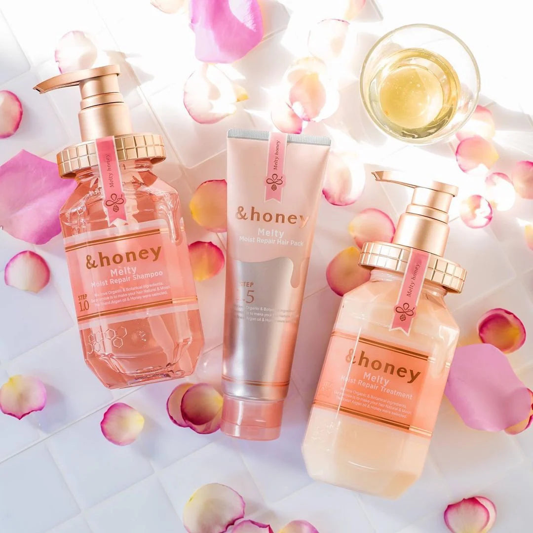 Skincare products with '&honey ' branding on a white background with rose petals.
