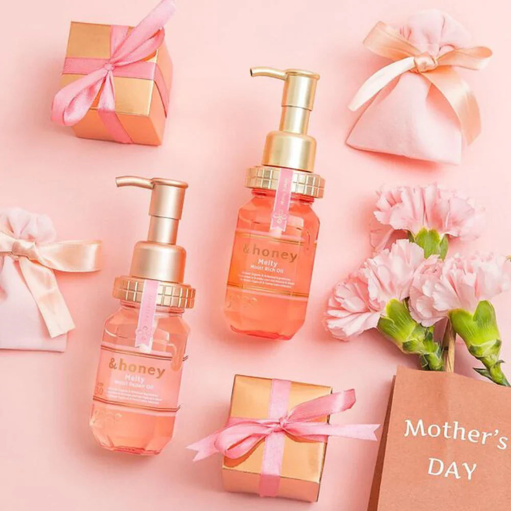 Two skincare bottles with gold pumps, pink flowers, and gift boxes on a pink background with 'Mother's Day' text.