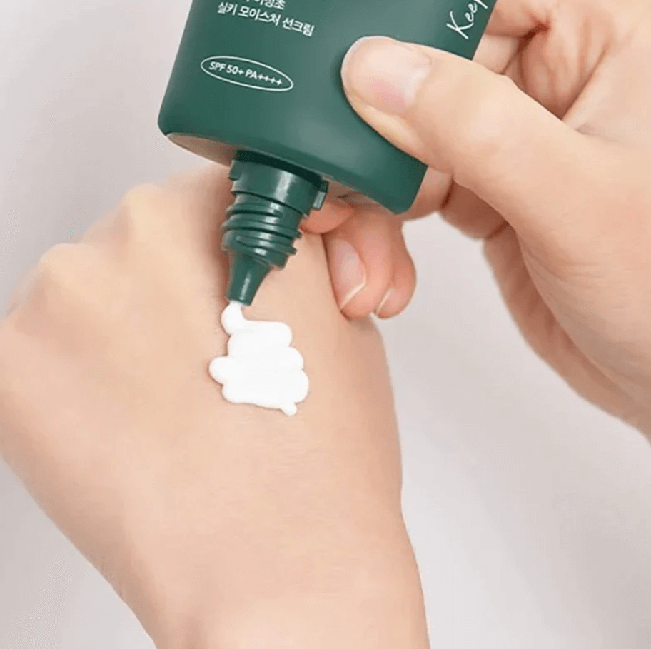 Applying Anua Heartleaf Silky Moisture Sun Cream on hand, showcasing its creamy texture and SPF 50+ protection.