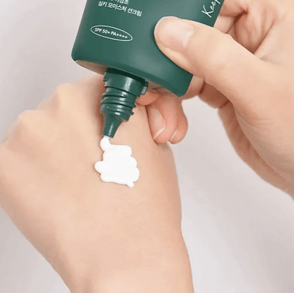 Applying Anua Heartleaf Silky Moisture Sun Cream on hand, showcasing its creamy texture and SPF 50+ protection.