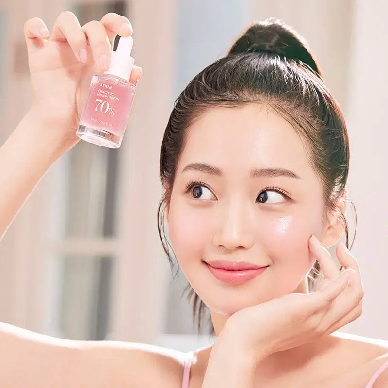 Model promoting Anua Peach 70% Niacinamide Serum, showcasing radiant skin and a fresh skincare routine.