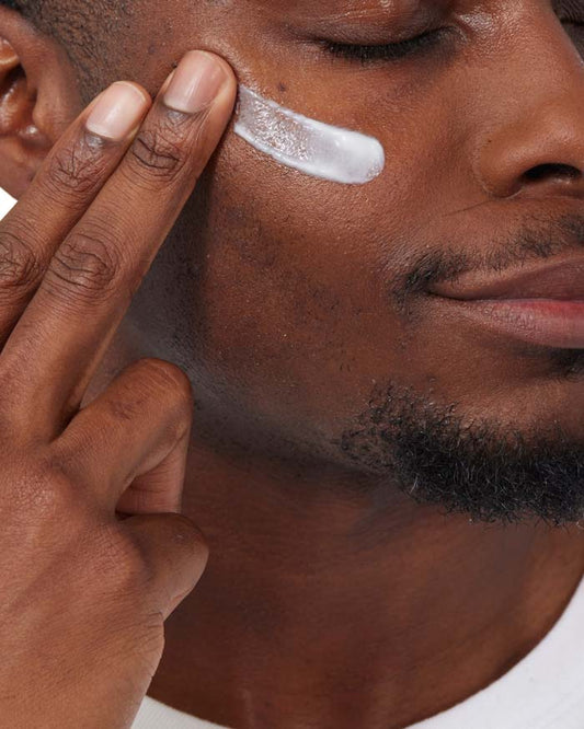 Man applying cream to his face with a close-up focus on the action.