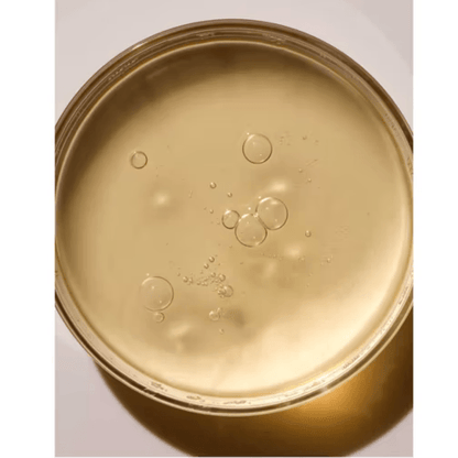 Close-up of ARKIVE All Day Everyday Shampoo showcasing its rich, golden texture with bubbles.