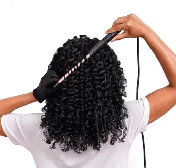 User styling hair with BaByliss Tight Curls Wand for defined, long-lasting tight curls.