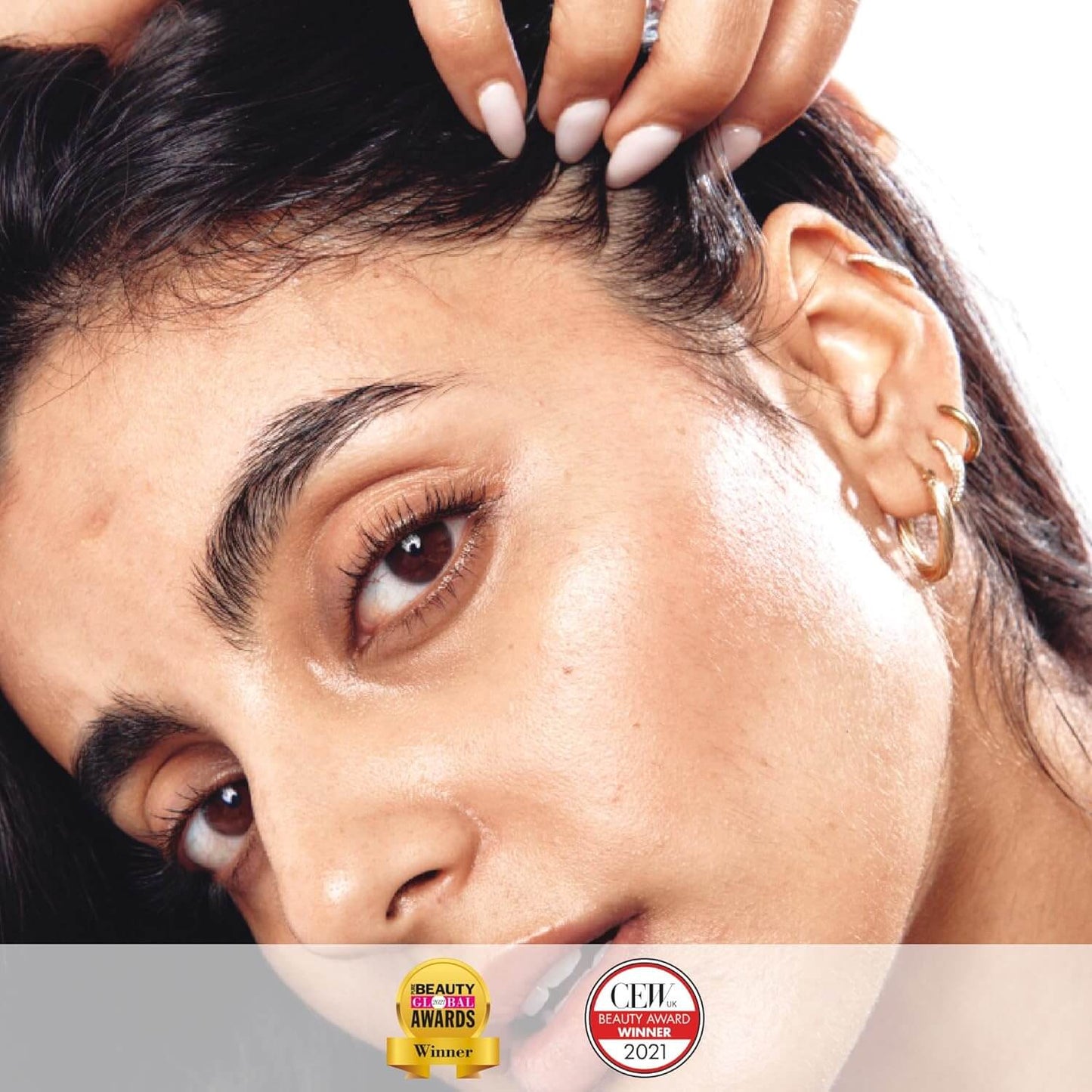 Close-up of a model showcasing glowing skin and accessories, highlighting a beauty award-winning product.