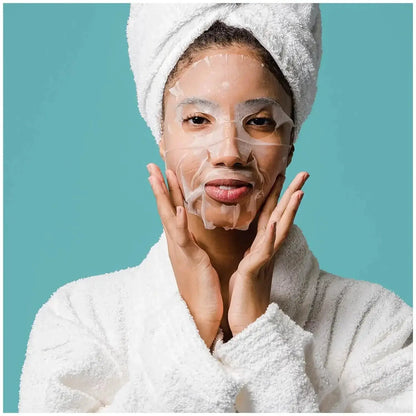 Woman in a white robe and towel using a BeautyPro RETINOL Anti-Ageing Facial Sheet Mask for skincare.