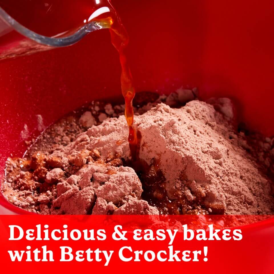 Pouring liquid into chocolate muffin mix for easy baking with Betty Crocker.