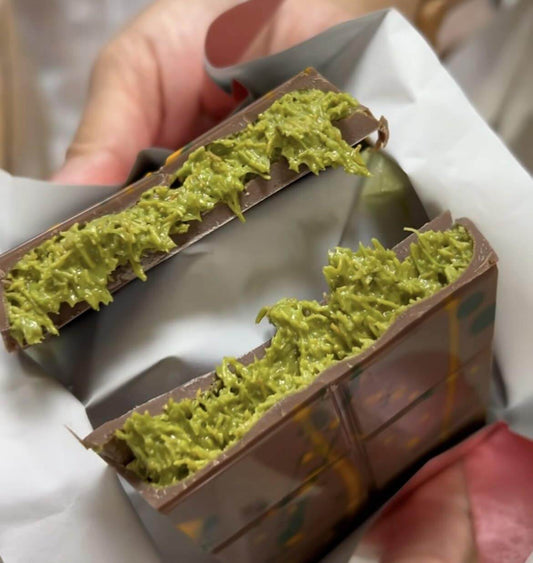 Close-up of Bolci Dubai chocolate bar filled with pistachio kadayif, showcasing its creamy green filling.